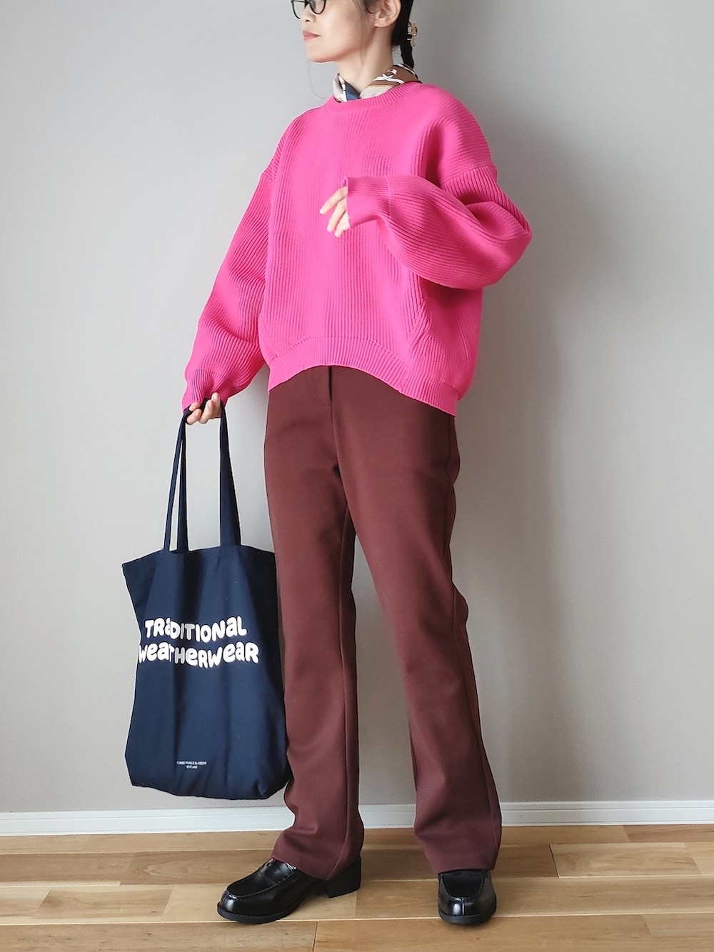 ピンク系のニット/セーター、ブラウン系のスラックス、ブルー系のトートバッグを着用したレディースの秋コーディネートの3枚目の写真