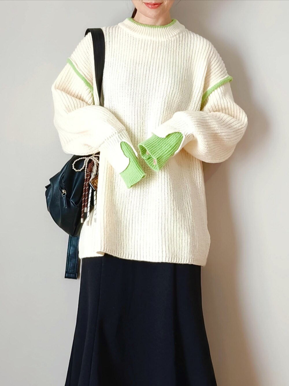 ホワイト系のニット/セーター、ブラック系のショルダーバッグ、ブラック系のシューズを着用したレディースの秋コーディネートの2枚目の写真