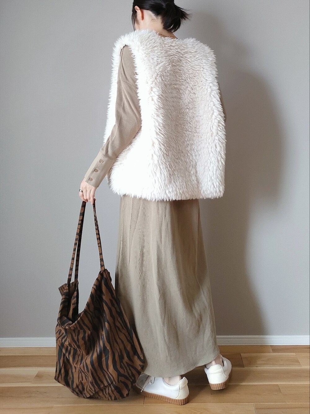 ホワイト系のベスト、ベージュ系のワンピース、ブラウン系のトートバッグを着用したレディースの秋コーディネートの3枚目の写真