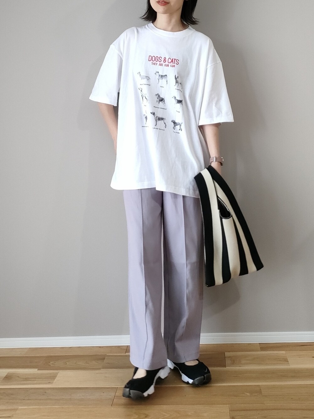 ホワイト系のTシャツ/カットソー、ブラック系のショルダーバッグ、ブラック系のスニーカーを着用したレディースの春コーディネートの2枚目の写真