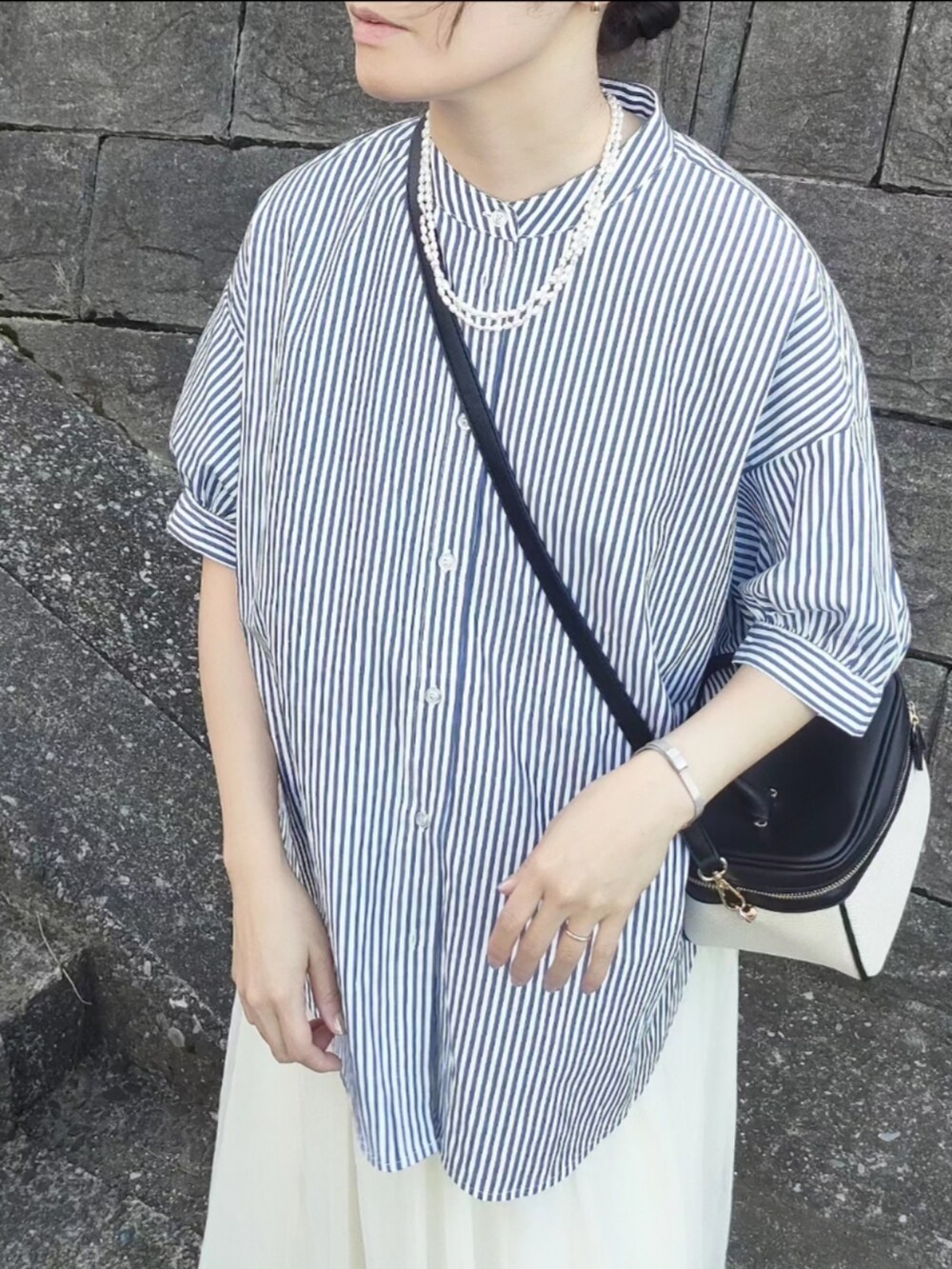 ブルー系のシャツ/ブラウス、ホワイト系のスカート、ブラック系のローファーを着用したレディースの春コーディネートの3枚目の写真