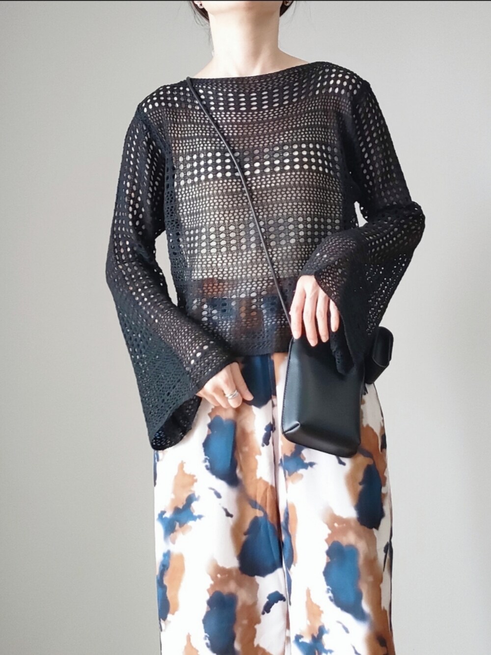 ブラック系のニット/セーター、ブラウン系のその他パンツ、ブラック系のショルダーバッグを着用したレディースの春コーディネートの3枚目の写真