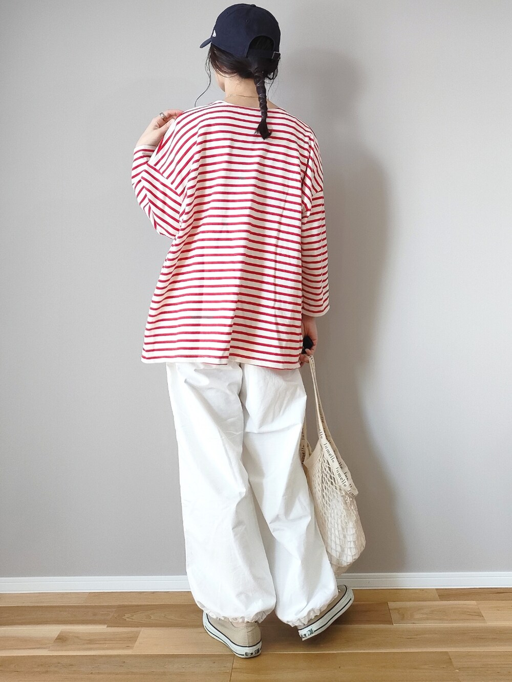 ホワイト系のカーゴパンツ、レッド系のTシャツ/カットソー、ブルー系のキャップを着用したレディースの春コーディネートの3枚目の写真