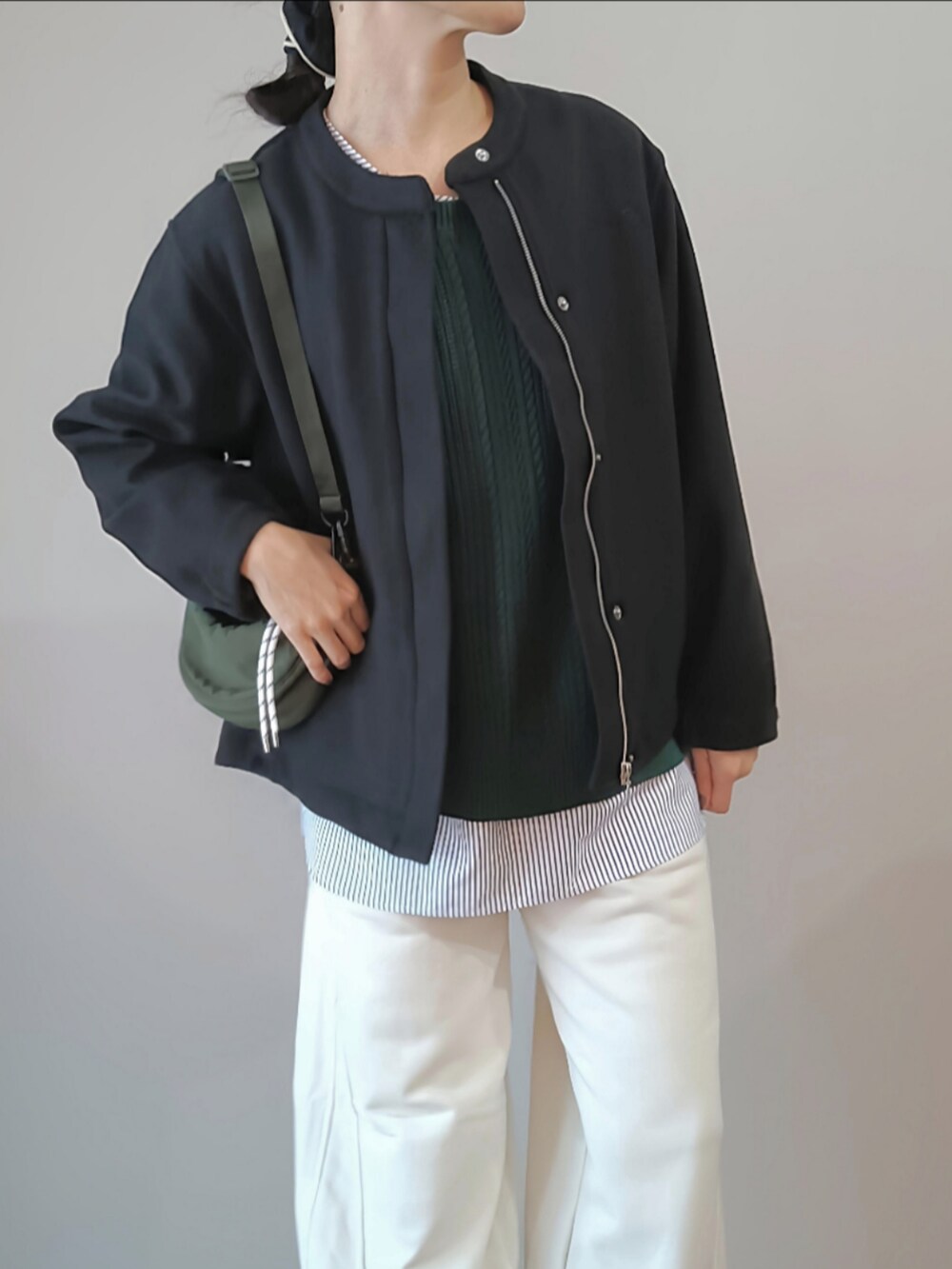 ブラック系のノーカラージャケット、グリーン系のシャツ/ブラウス、ブラック系のスニーカーを着用したレディースの秋コーディネートの2枚目の写真