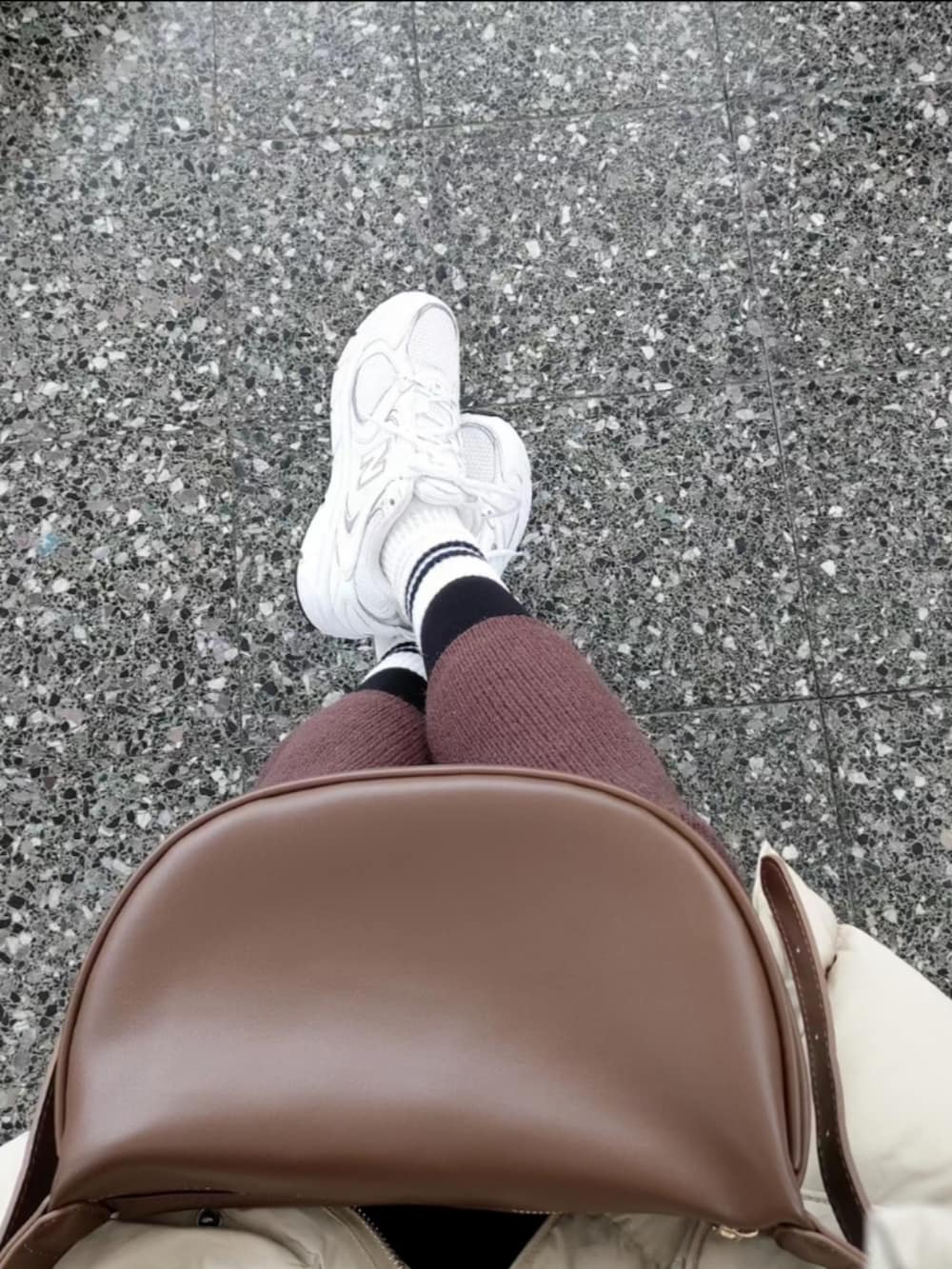 ブラウン系のワンピース、ブラウン系のショルダーバッグ、ベージュ系のダウンジャケット/コートを着用したレディースの冬コーディネートの3枚目の写真