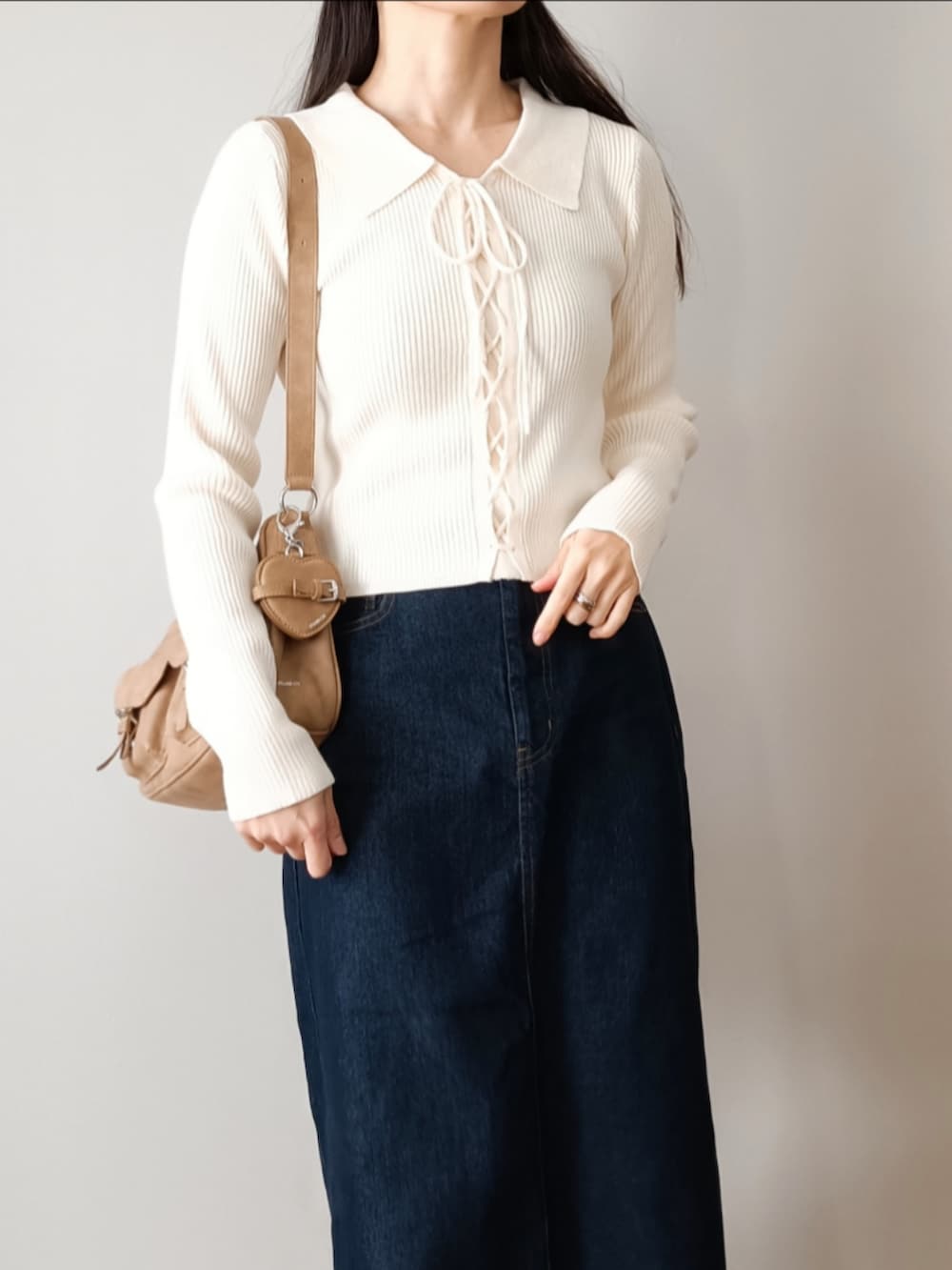 ブルー系のデニムスカート、ホワイト系のニット/セーター、ブラック系のローファーを着用したレディースの冬コーディネートの3枚目の写真