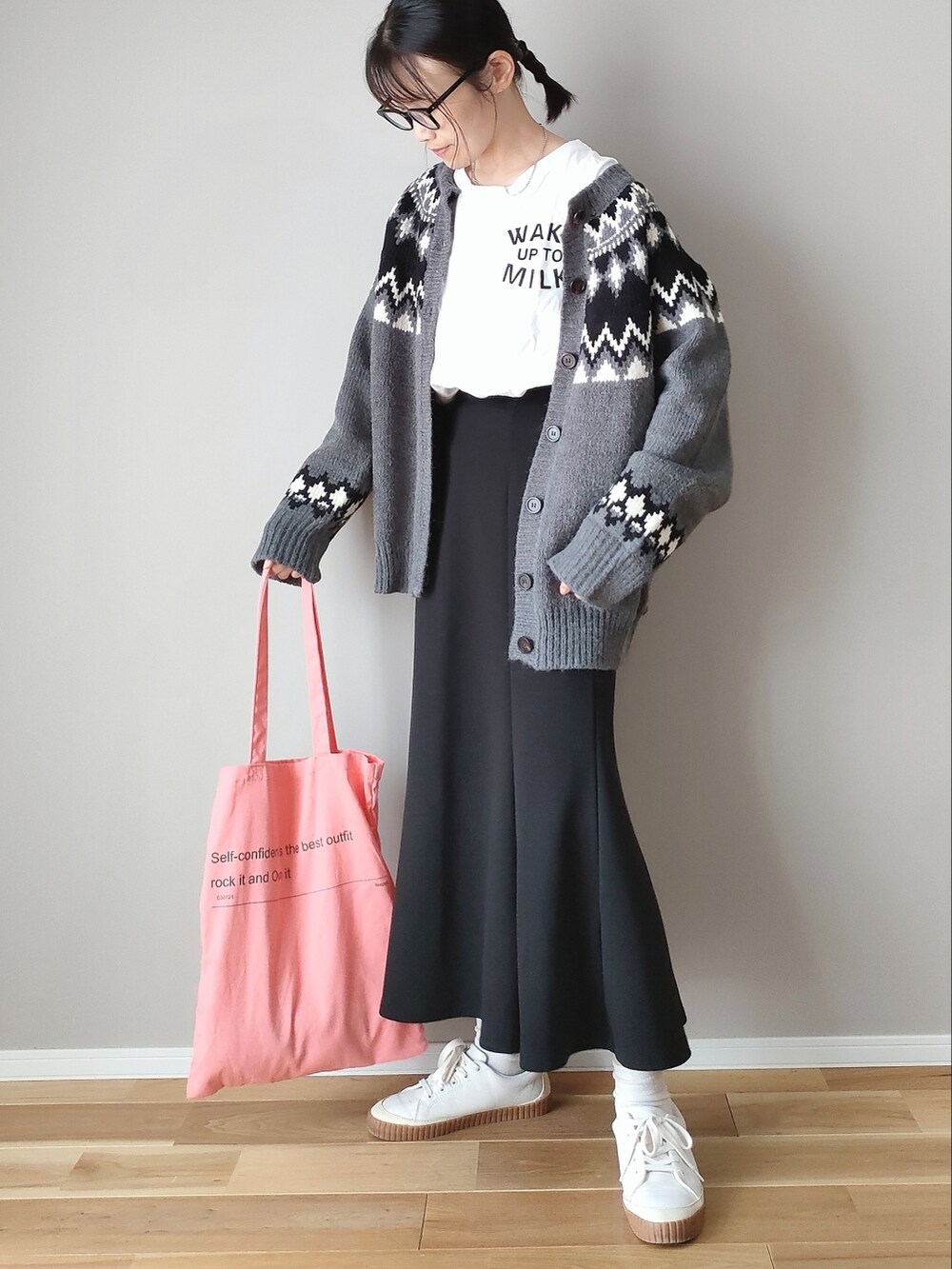 グレー系のニット/セーター、ブラック系のスカート、ピンク系のトートバッグを着用したレディースの秋コーディネートの2枚目の写真