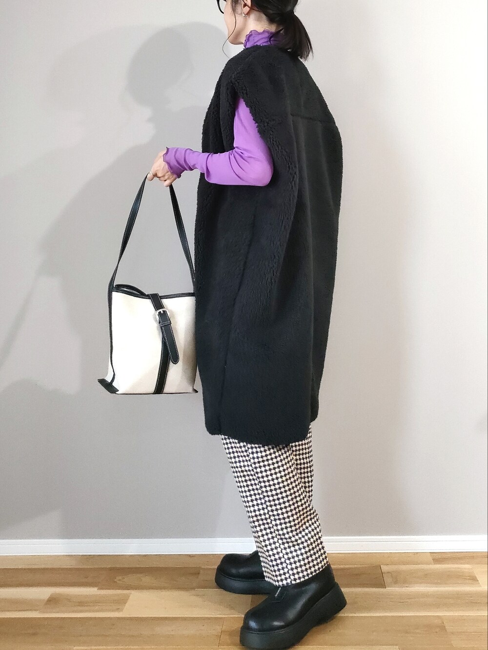 ブラック系のブーツ、ブラック系のベスト、パープル系のTシャツ/カットソーを着用したレディースの秋コーディネートの3枚目の写真