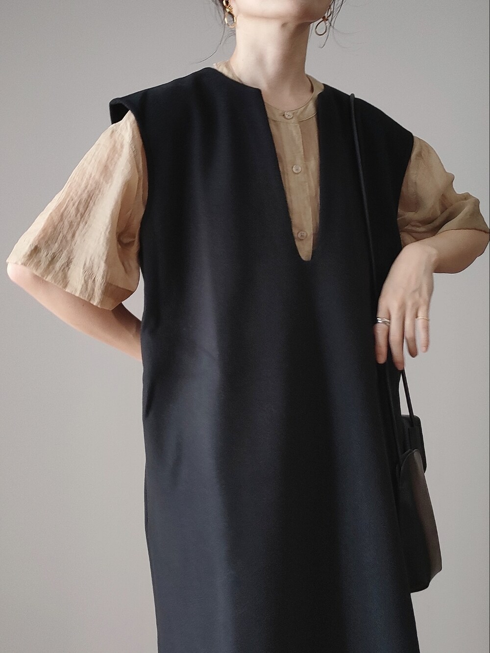 ブラック系のワンピース、ベージュ系のシャツ/ブラウス、ブラック系のショルダーバッグを着用したレディースの秋コーディネートの2枚目の写真