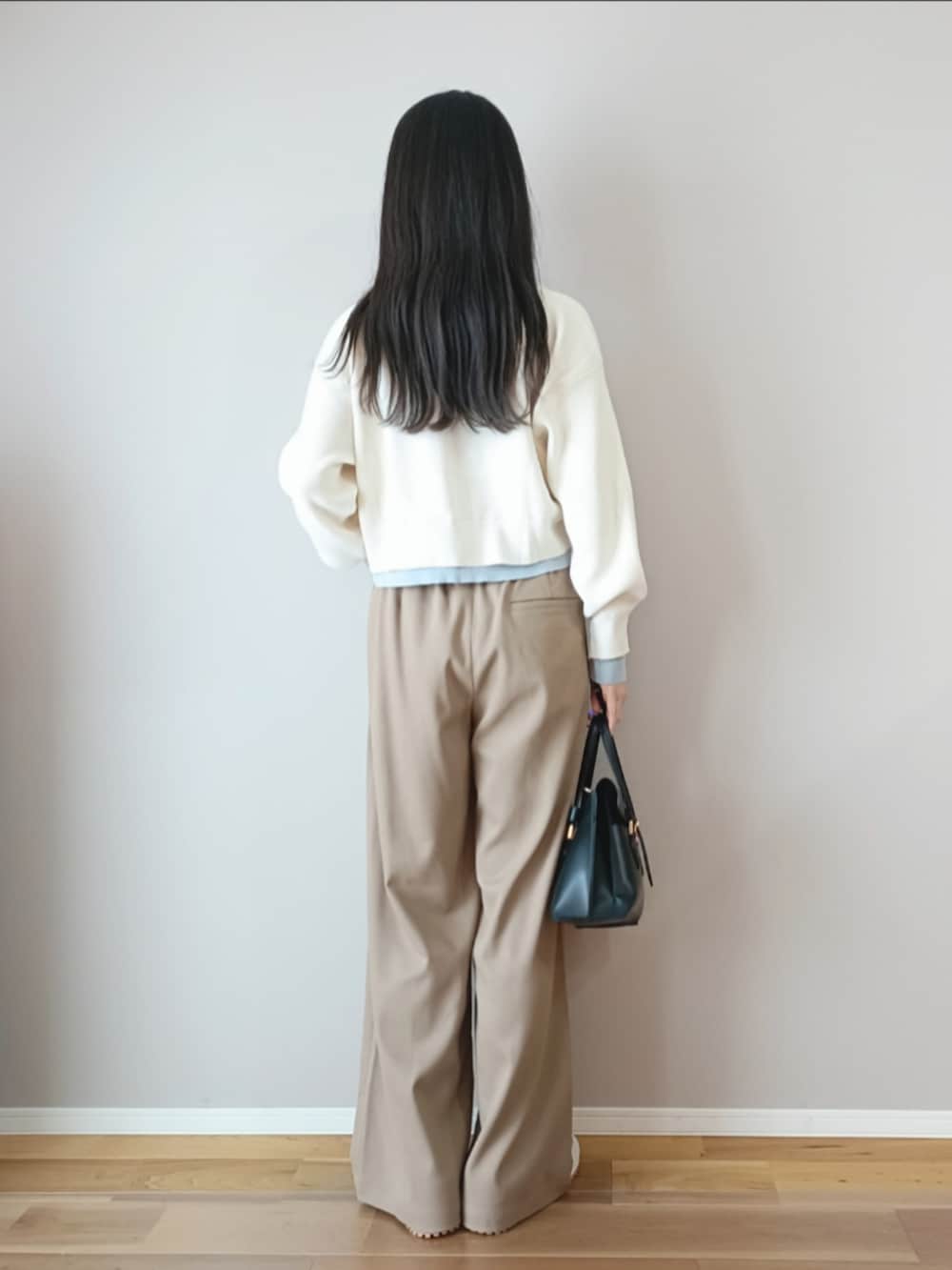 ホワイト系のカーディガン/ボレロ、ベージュ系のスニーカー、ブラック系のハンドバッグを着用したレディースの春コーディネートの3枚目の写真