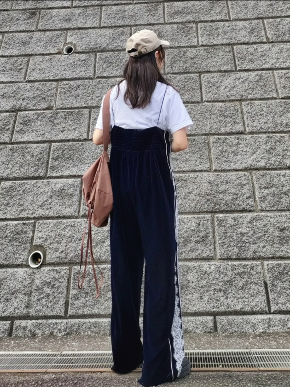 ブルー系のサロペット/オーバーオール、ホワイト系のTシャツ/カットソー、ブラック系のスニーカーを着用したレディースの秋コーディネートの4枚目の写真