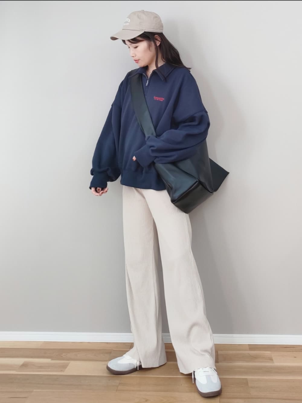 ブルー系のスウェット、ブラック系のショルダーバッグ、グレー系のスニーカーを着用したレディースの冬コーディネートの4枚目の写真