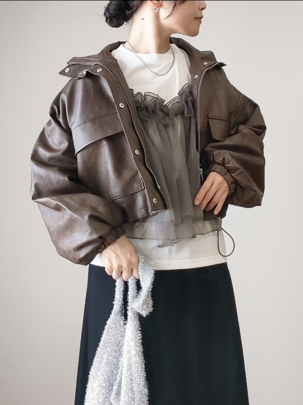 ブラウン系のブルゾン、ホワイト系のTシャツ/カットソー、ブラック系のスカートを着用したレディースの秋コーディネートの4枚目の写真