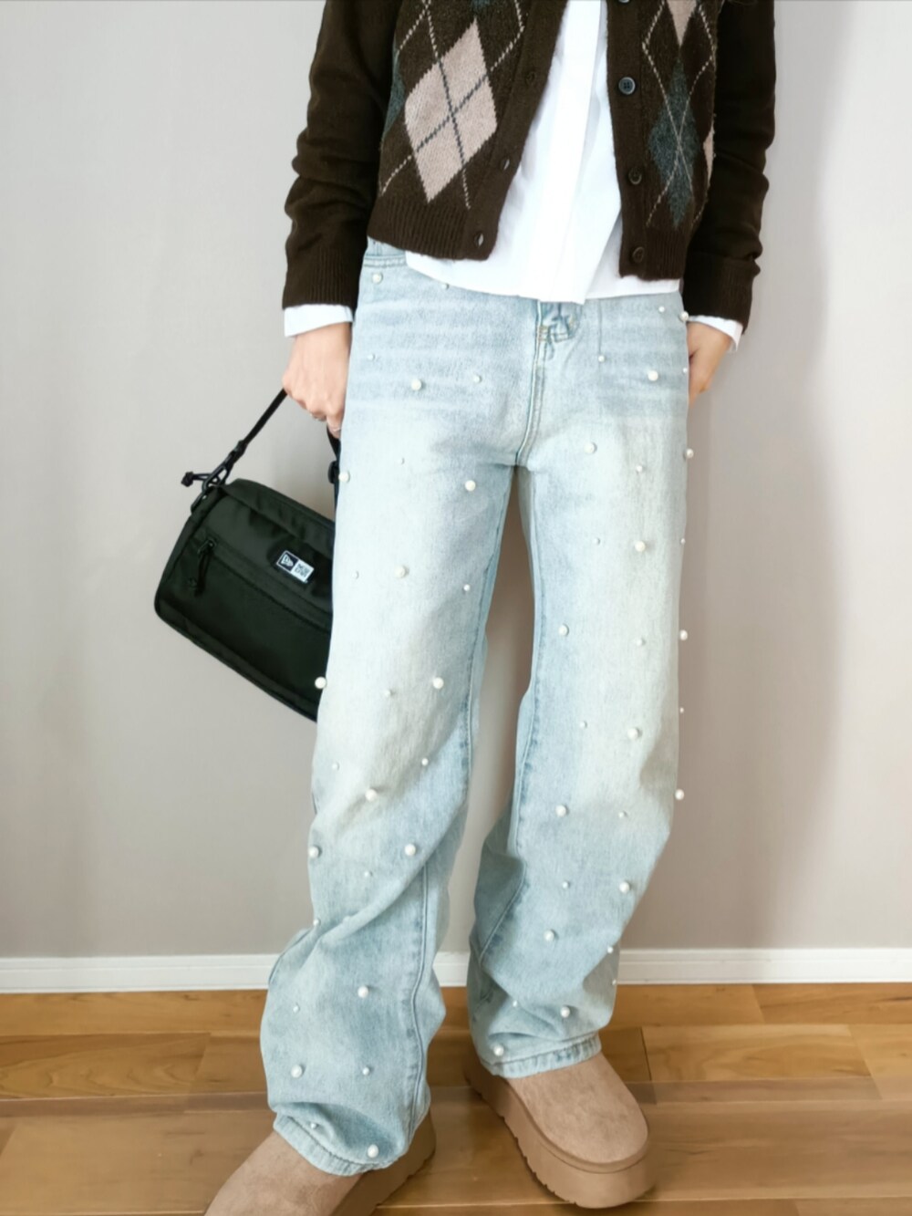 ブルー系のデニムパンツ、ブラック系のショルダーバッグ、ブラウン系のカーディガン/ボレロを着用したレディースの冬コーディネートの4枚目の写真