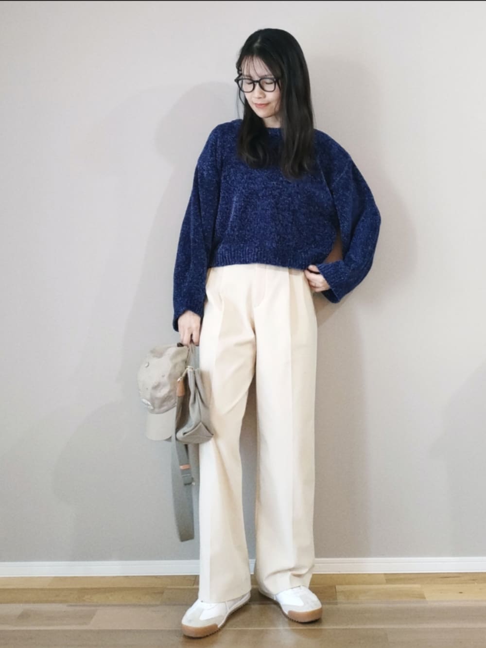 ブルー系のニット/セーター、ホワイト系のブルゾン、ホワイト系のパンツを着用したレディースの冬コーディネートの2枚目の写真