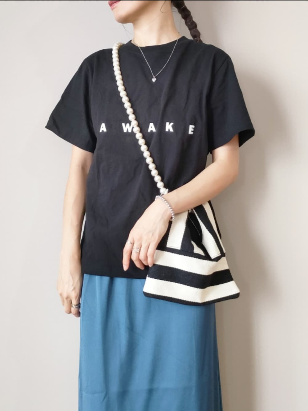 ブラック系のTシャツ/カットソー、ホワイト系のショルダーバッグ、ブルー系のスカートを着用したレディースの夏コーディネートの2枚目の写真