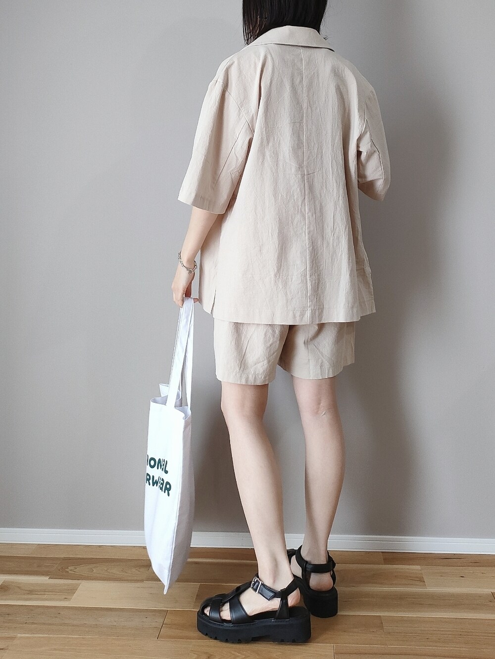 ベージュ系のテーラードジャケット、ベージュ系のその他パンツ、ホワイト系のトートバッグを着用したレディースの春コーディネートの4枚目の写真