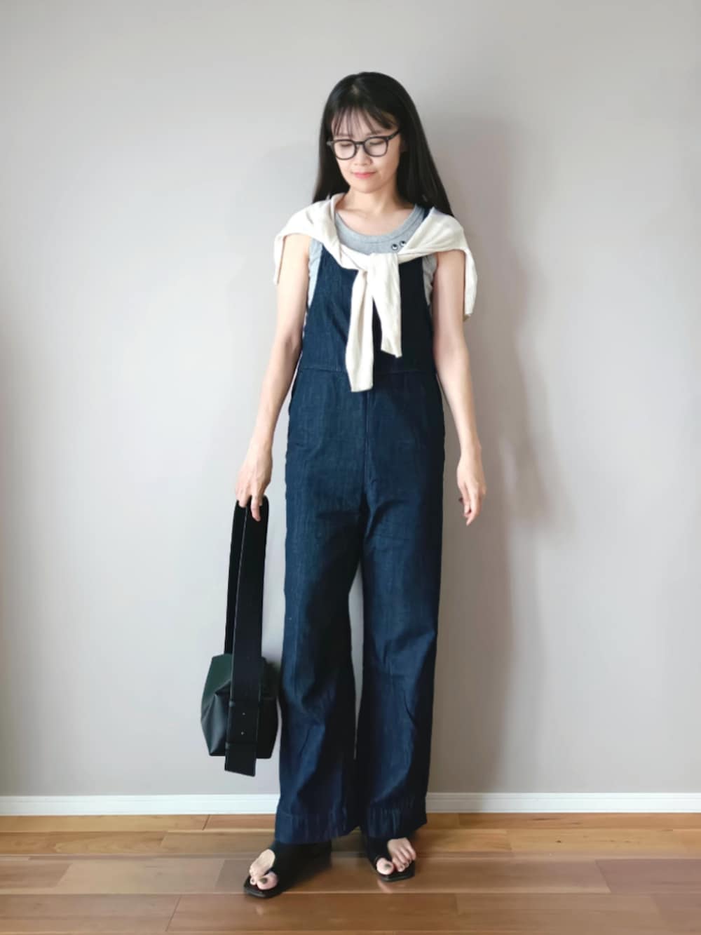 ブラック系のショルダーバッグ、ブラック系のサンダル、グレー系のタンクトップを着用したレディースの夏コーディネートの2枚目の写真