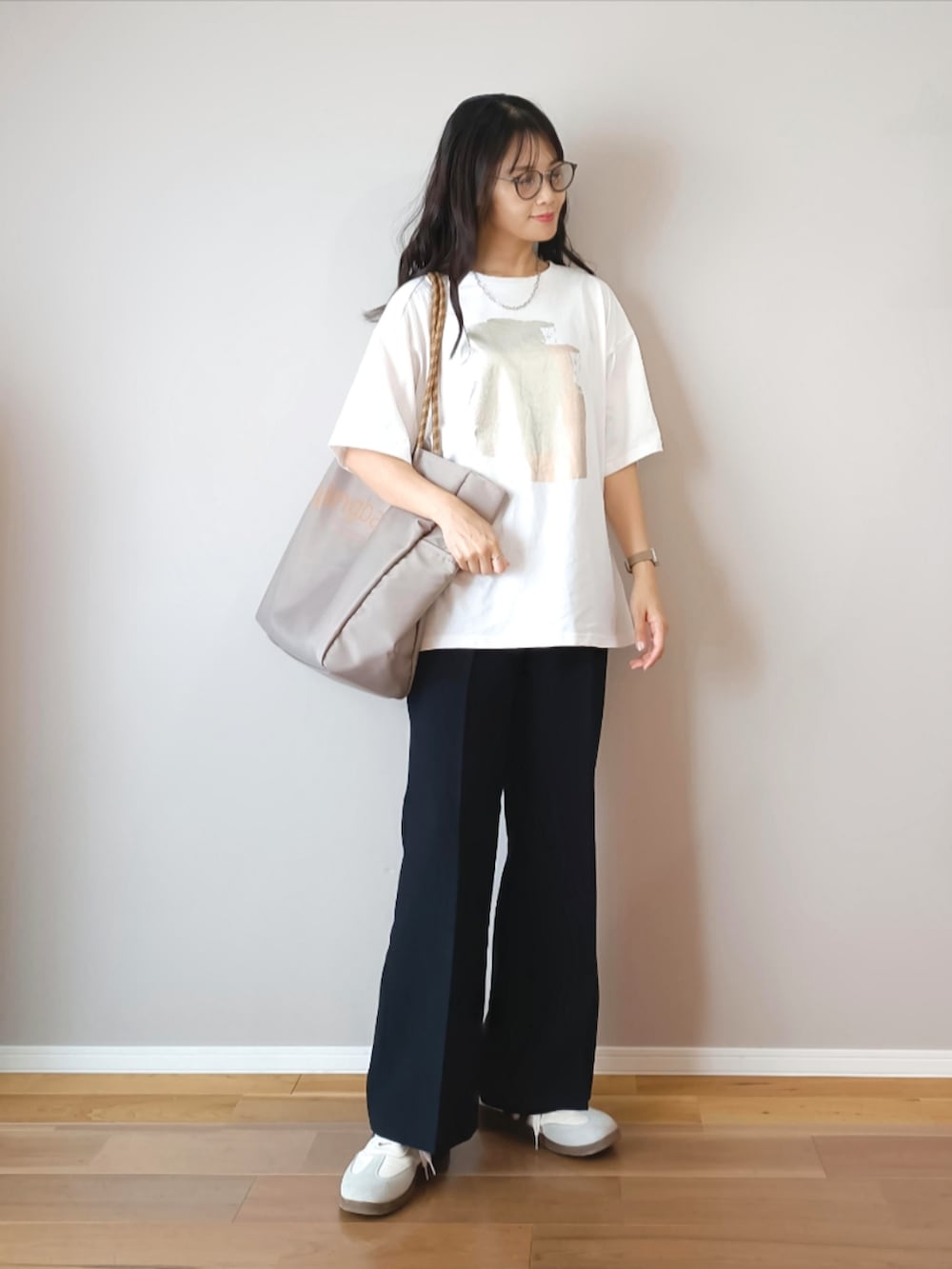 ホワイト系のTシャツ/カットソー、ブラック系のスラックス、グレー系のトートバッグを着用したレディースの夏コーディネートの2枚目の写真