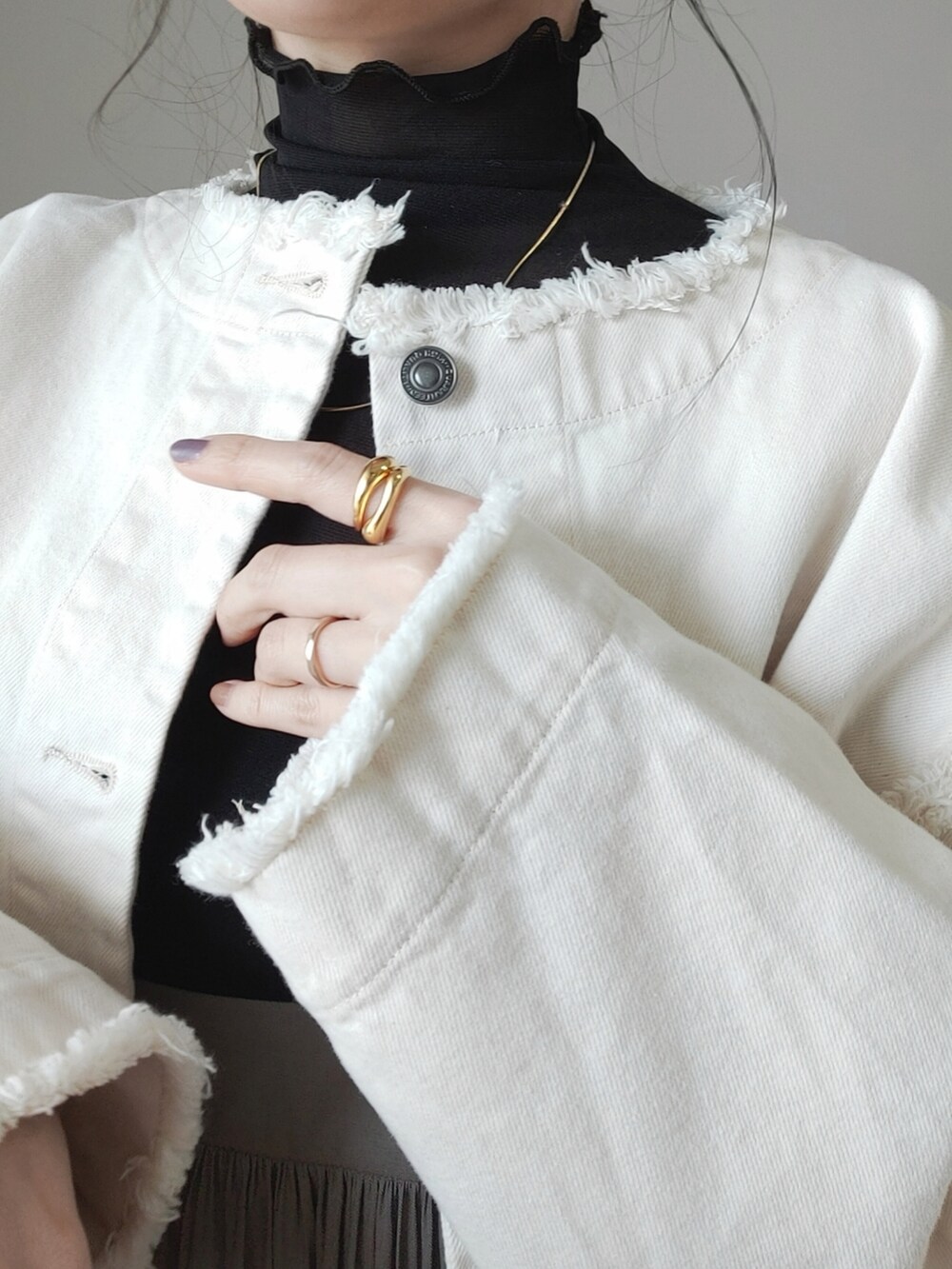 ホワイト系のデニムジャケット、グリーン系のスカート、グレー系のハンドバッグを着用したレディースの冬コーディネートの2枚目の写真