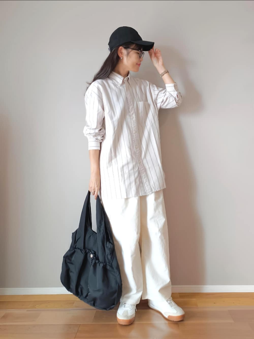 ブラック系のトートバッグ、ベージュ系のシャツ/ブラウス、ホワイト系のカーゴパンツを着用したレディースの秋コーディネートの4枚目の写真