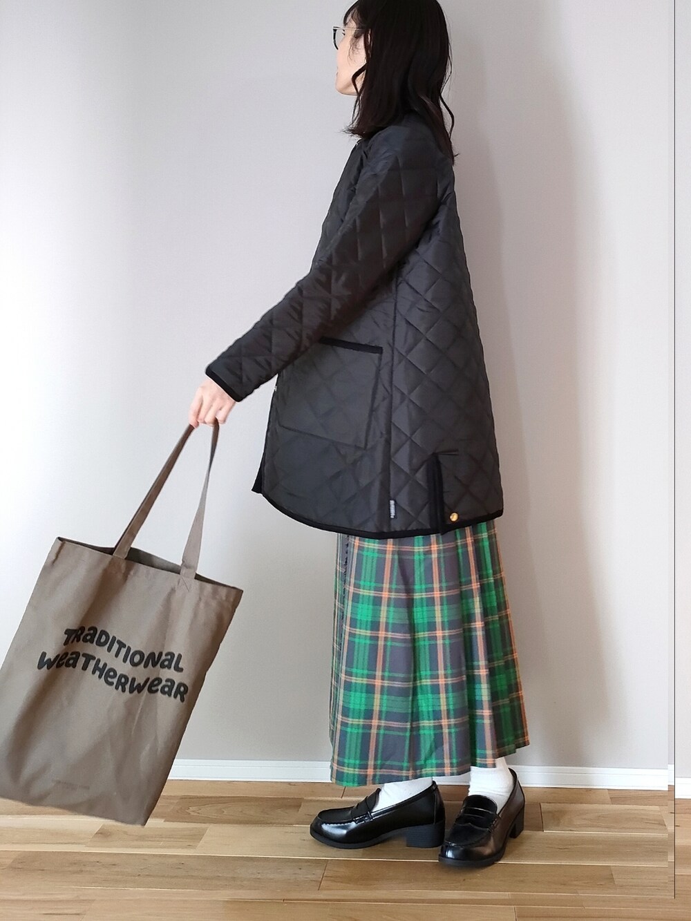 ブラック系のその他アウター、ブラウン系のトートバッグ、ベージュ系のニット/セーターを着用したレディースの冬コーディネートの3枚目の写真