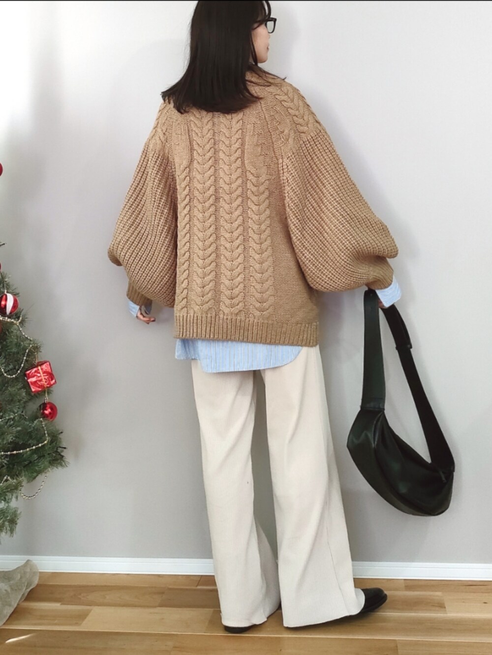 ベージュ系のニット/セーター、ブラック系のショルダーバッグ、ブラック系のレインシューズを着用したレディースの冬コーディネートの4枚目の写真