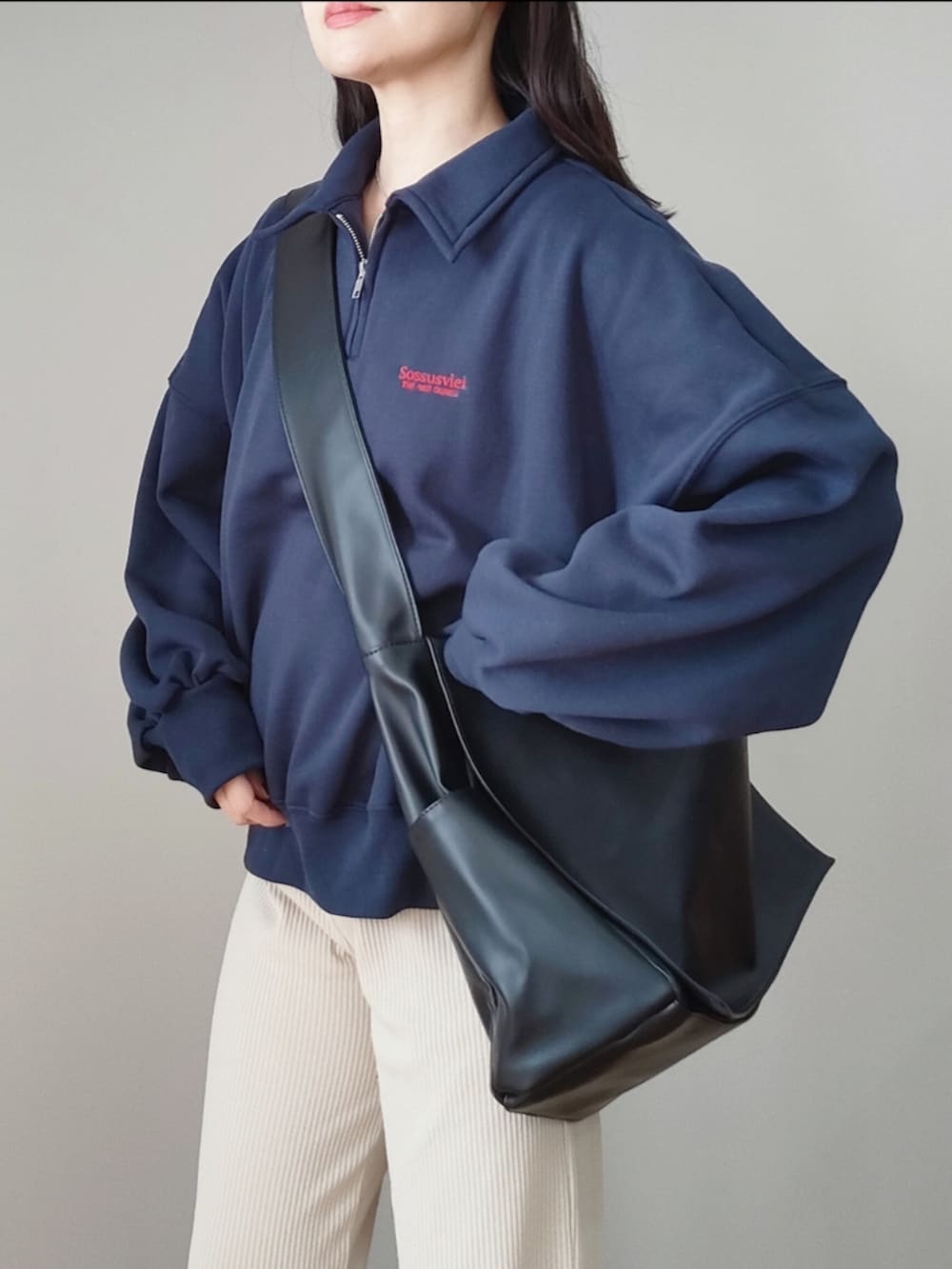 ブルー系のスウェット、ブラック系のショルダーバッグ、グレー系のスニーカーを着用したレディースの冬コーディネートの3枚目の写真