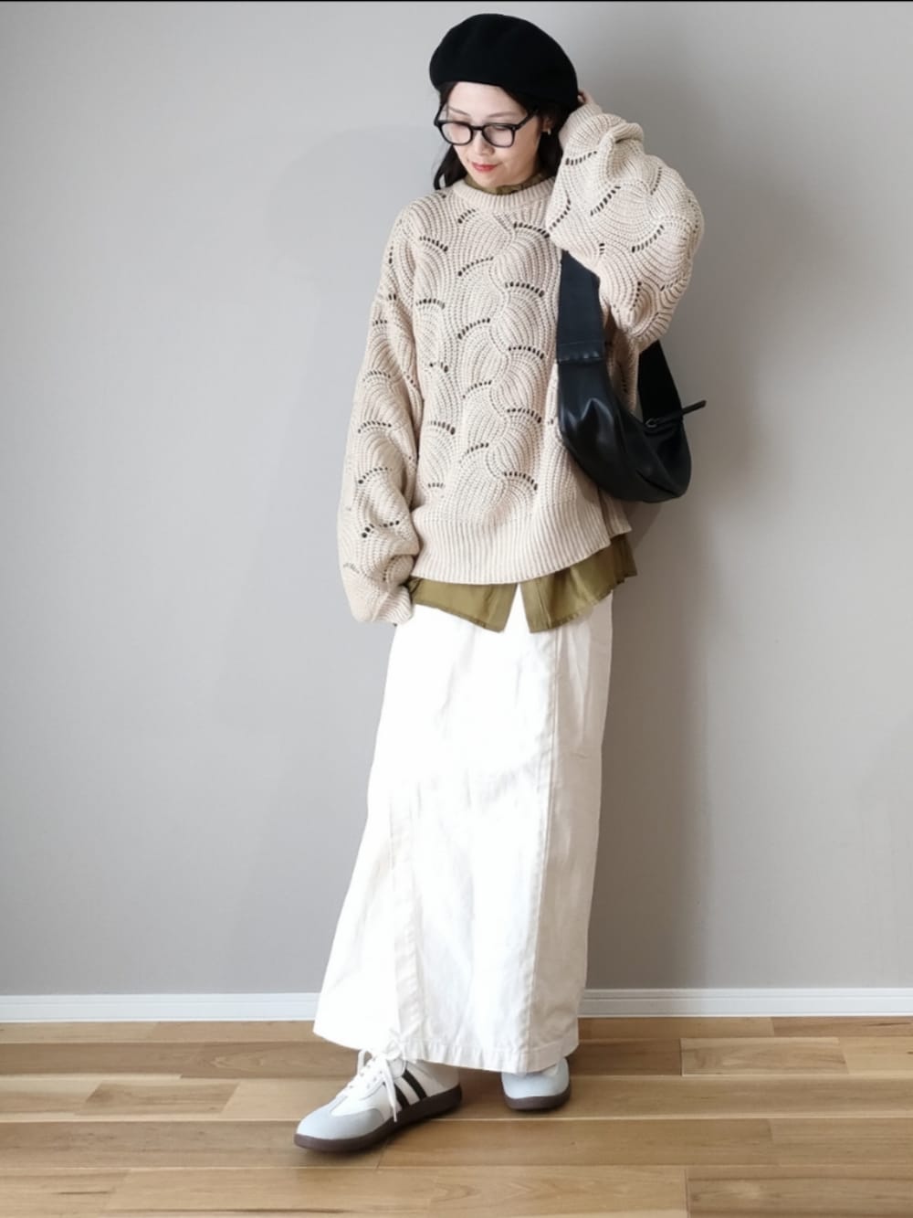 ホワイト系のニット/セーター、ブラック系のショルダーバッグ、グレー系のスニーカーを着用したレディースの秋コーディネートの4枚目の写真