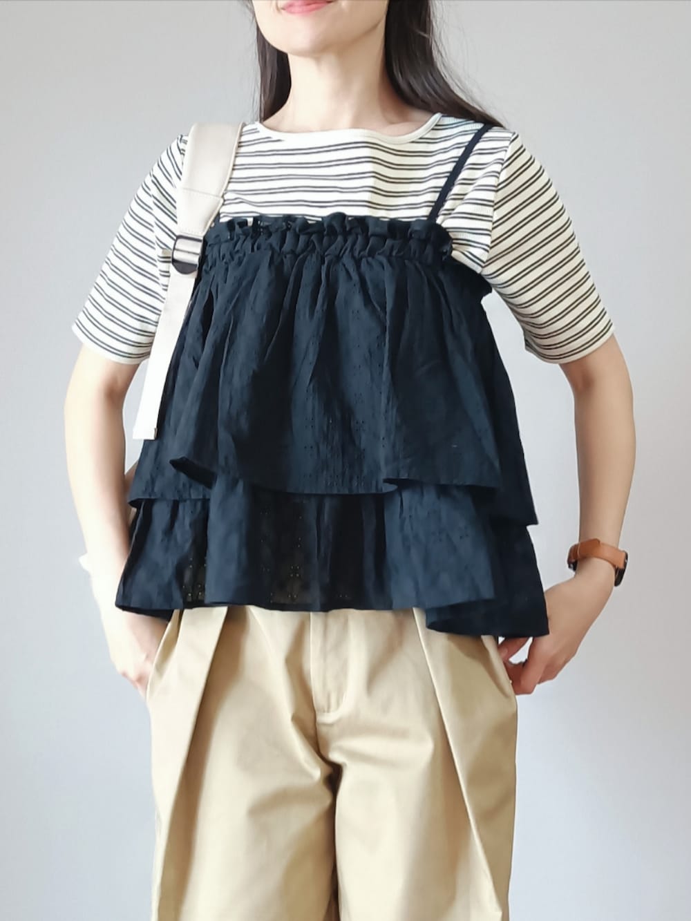 ブラック系のスカート、ホワイト系のTシャツ/カットソー、ベージュ系のチノパンツを着用したレディースの春コーディネートの5枚目の写真