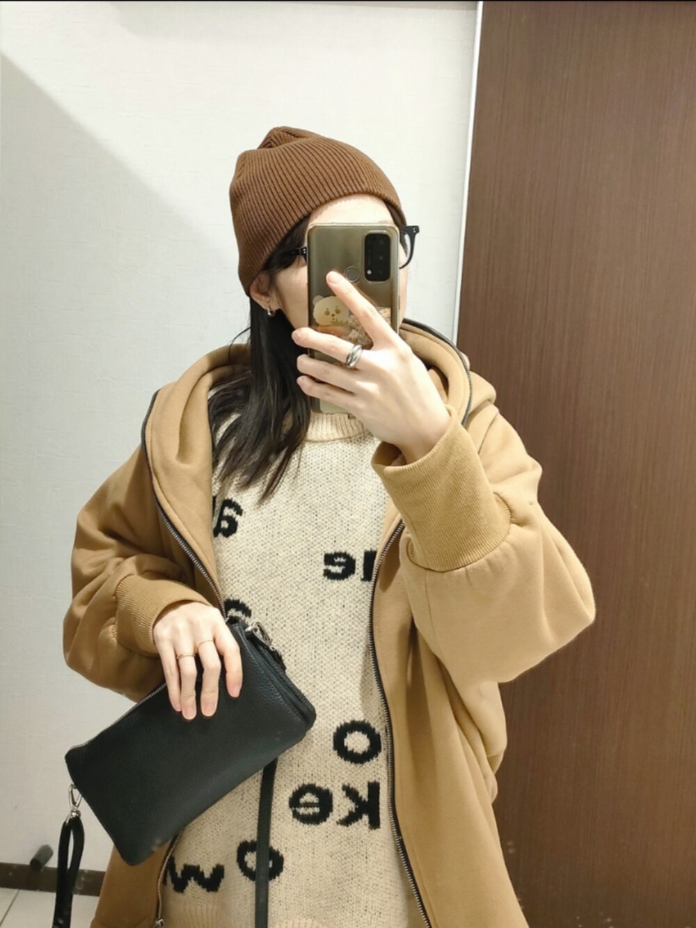 ベージュ系のニット/セーター、ブラック系のショルダーバッグ、ホワイト系のマタニティウェア/グッズを着用したレディースの冬コーディネートの3枚目の写真