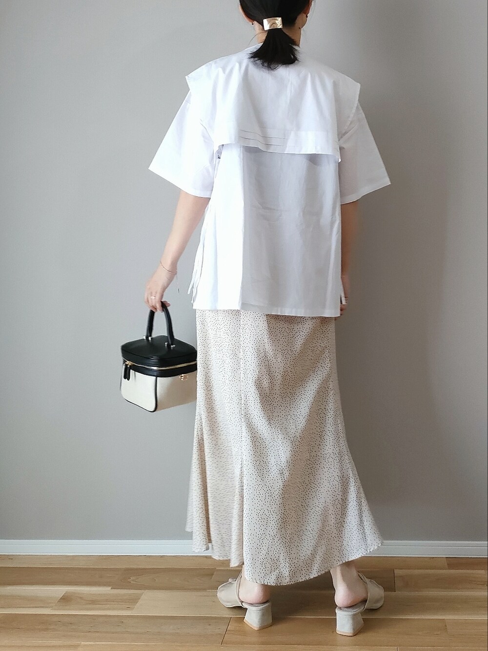 ホワイト系のシャツ/ブラウス、ホワイト系のスカート、ブラック系のハンドバッグを着用したレディースの夏コーディネートの3枚目の写真