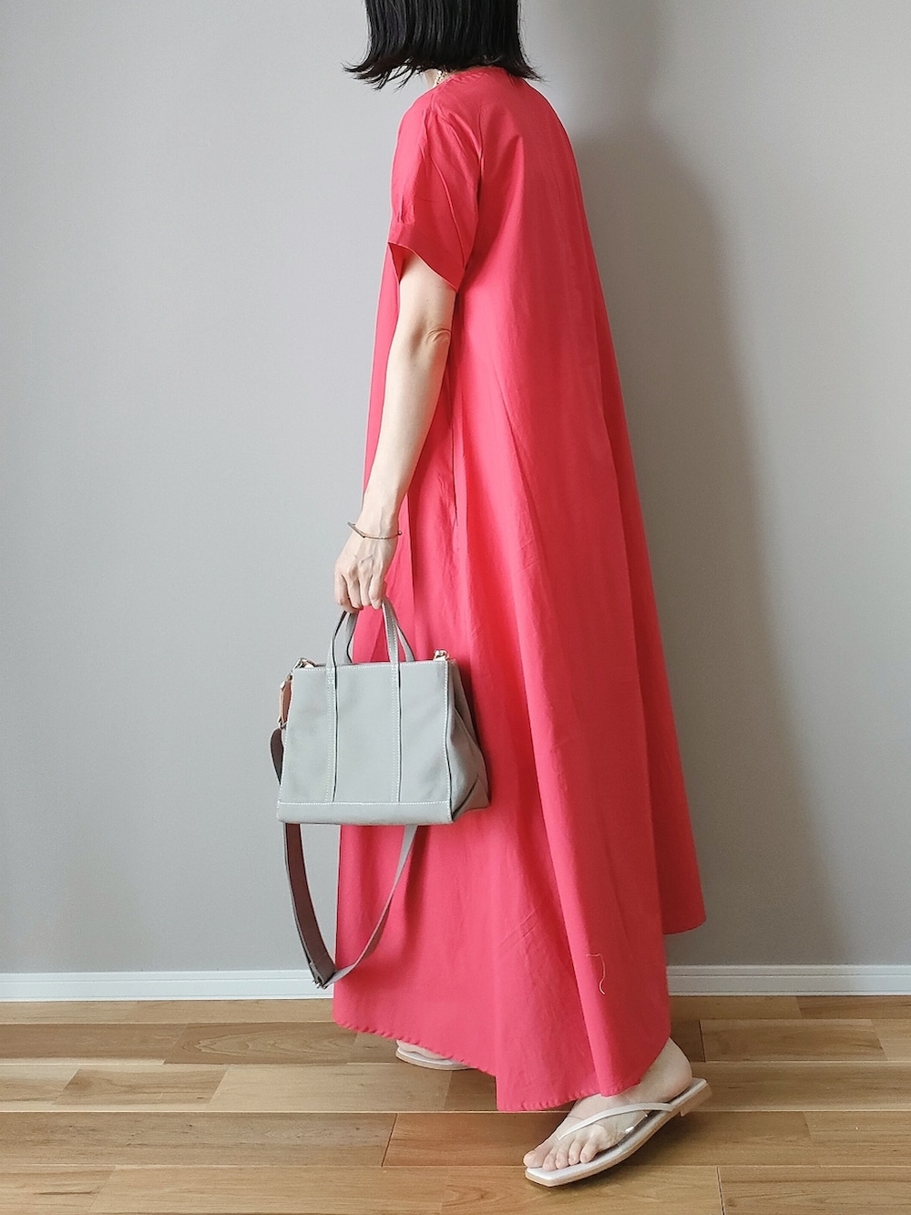 レッド系のワンピース、グレー系のハンドバッグ、ホワイト系のサンダルを着用したレディースの夏コーディネートの4枚目の写真