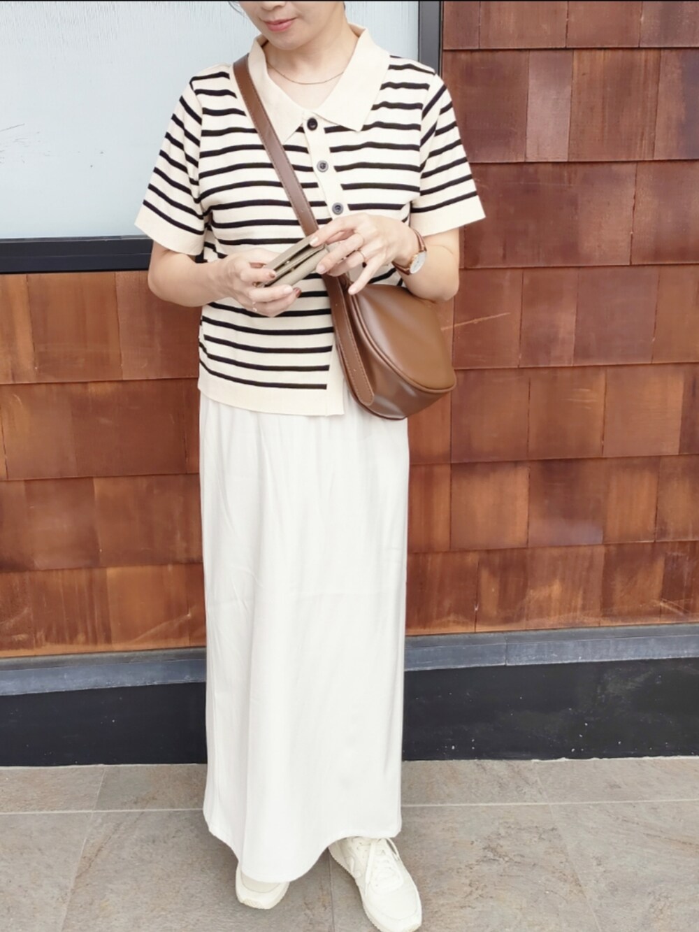 ブラウン系のショルダーバッグ、ホワイト系のスカート、ホワイト系のニット/セーターを着用したレディースの秋コーディネートの4枚目の写真