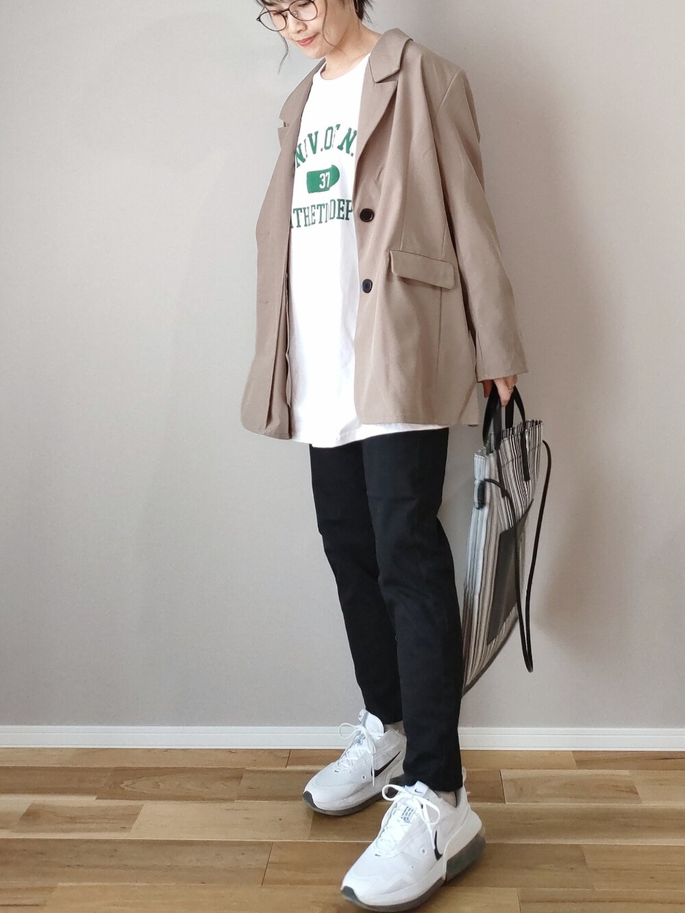 ホワイト系のTシャツ/カットソー、グレー系のテーラードジャケット、ブラック系のデニムパンツを着用したレディースの春コーディネートの2枚目の写真