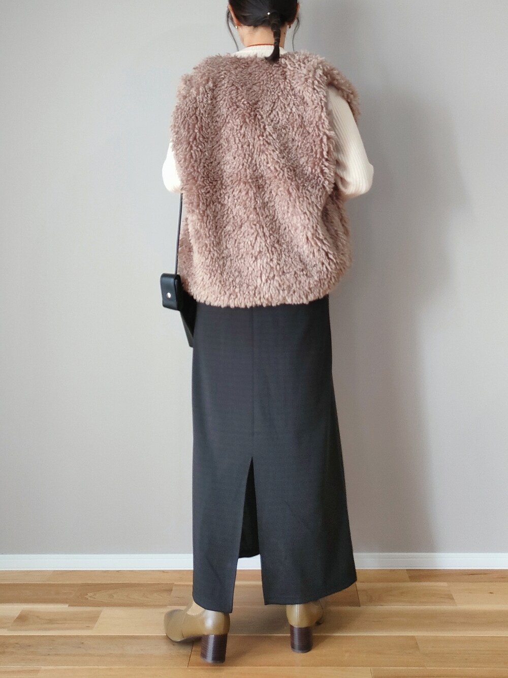 ベージュ系のベスト、ブラック系のワンピース、グリーン系のブーツを着用したレディースの秋コーディネートの4枚目の写真