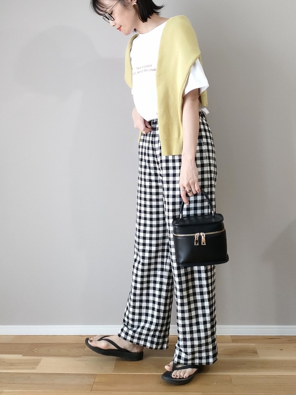 レッド系のTシャツ/カットソー、イエロー系のカーディガン/ボレロ、ブラック系のショルダーバッグを着用したレディースの春コーディネートの3枚目の写真