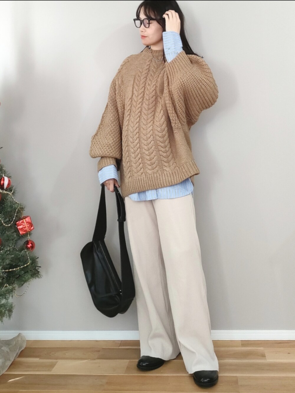 ベージュ系のニット/セーター、ブラック系のショルダーバッグ、ブラック系のレインシューズを着用したレディースの冬コーディネートの3枚目の写真