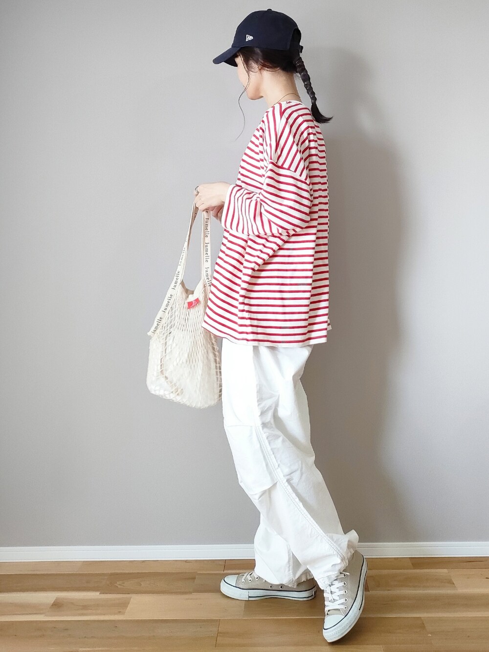 ホワイト系のカーゴパンツ、レッド系のTシャツ/カットソー、ブルー系のキャップを着用したレディースの春コーディネートの2枚目の写真