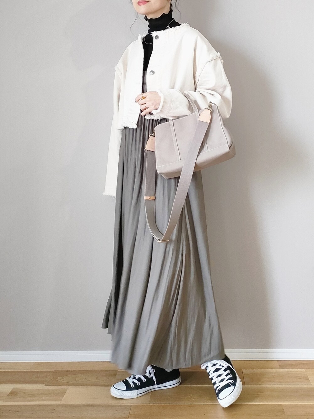 ホワイト系のデニムジャケット、グリーン系のスカート、グレー系のハンドバッグを着用したレディースの冬コーディネートの3枚目の写真