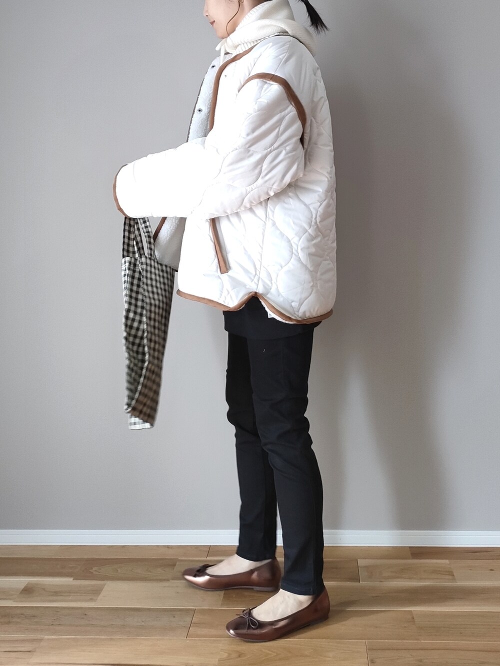 ホワイト系のブルゾン、ブラック系のデニムパンツ、ブラック系のスウェットを着用したレディースの秋コーディネートの4枚目の写真