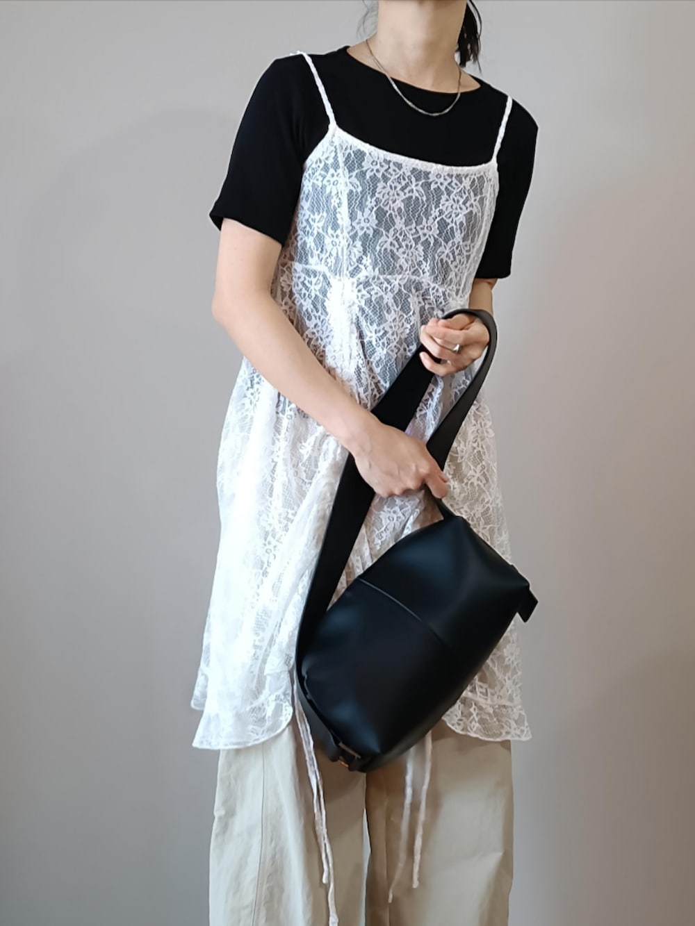 ホワイト系のチュニック、ホワイト系のパンツ、ブラック系のTシャツ/カットソーを着用したレディースの春コーディネートの3枚目の写真