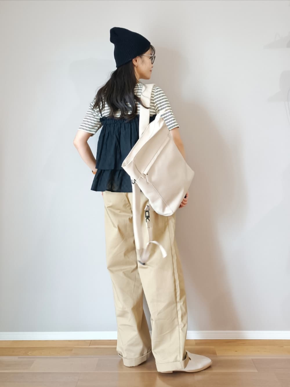 ブラック系のスカート、ホワイト系のTシャツ/カットソー、ベージュ系のチノパンツを着用したレディースの春コーディネートの3枚目の写真