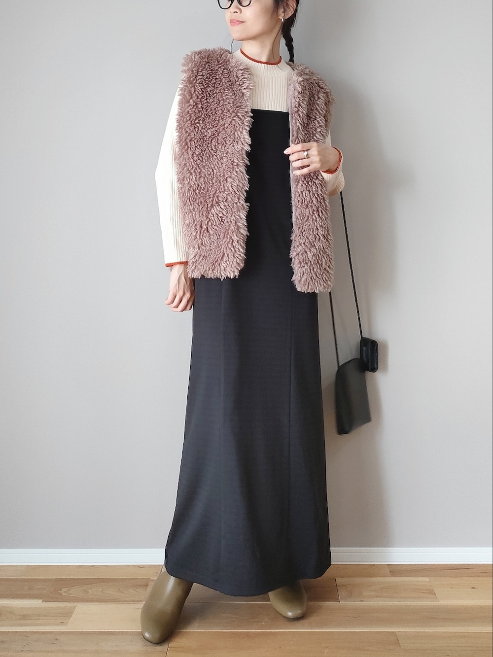 ベージュ系のベスト、ブラック系のワンピース、グリーン系のブーツを着用したレディースの秋コーディネートの3枚目の写真