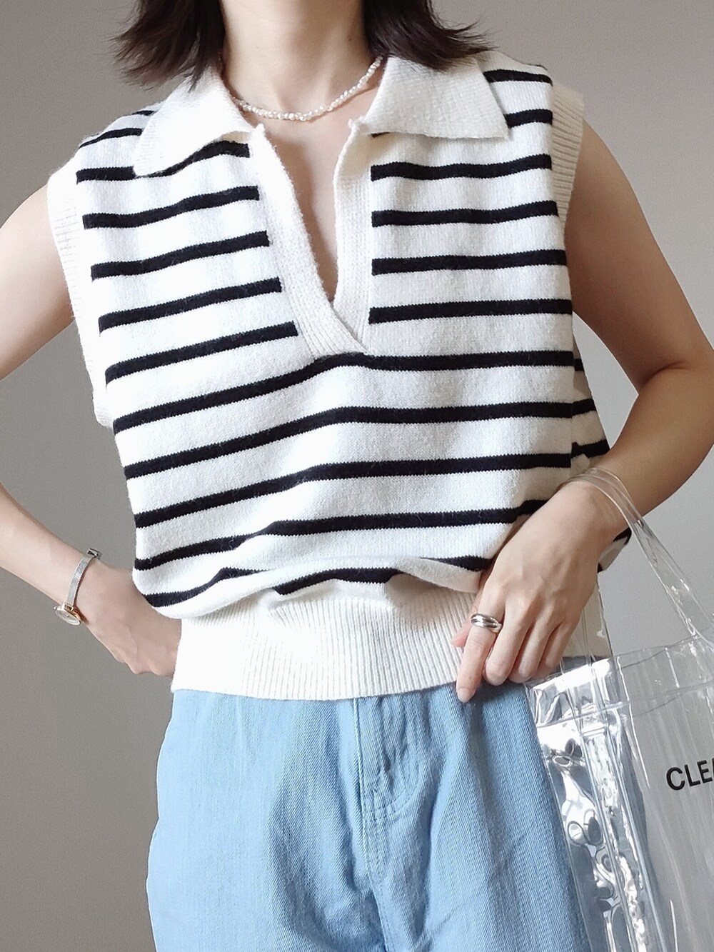 ホワイト系のベスト、ピンク系のデニムパンツ、ホワイト系のサンダルを着用したレディースの夏コーディネートの3枚目の写真