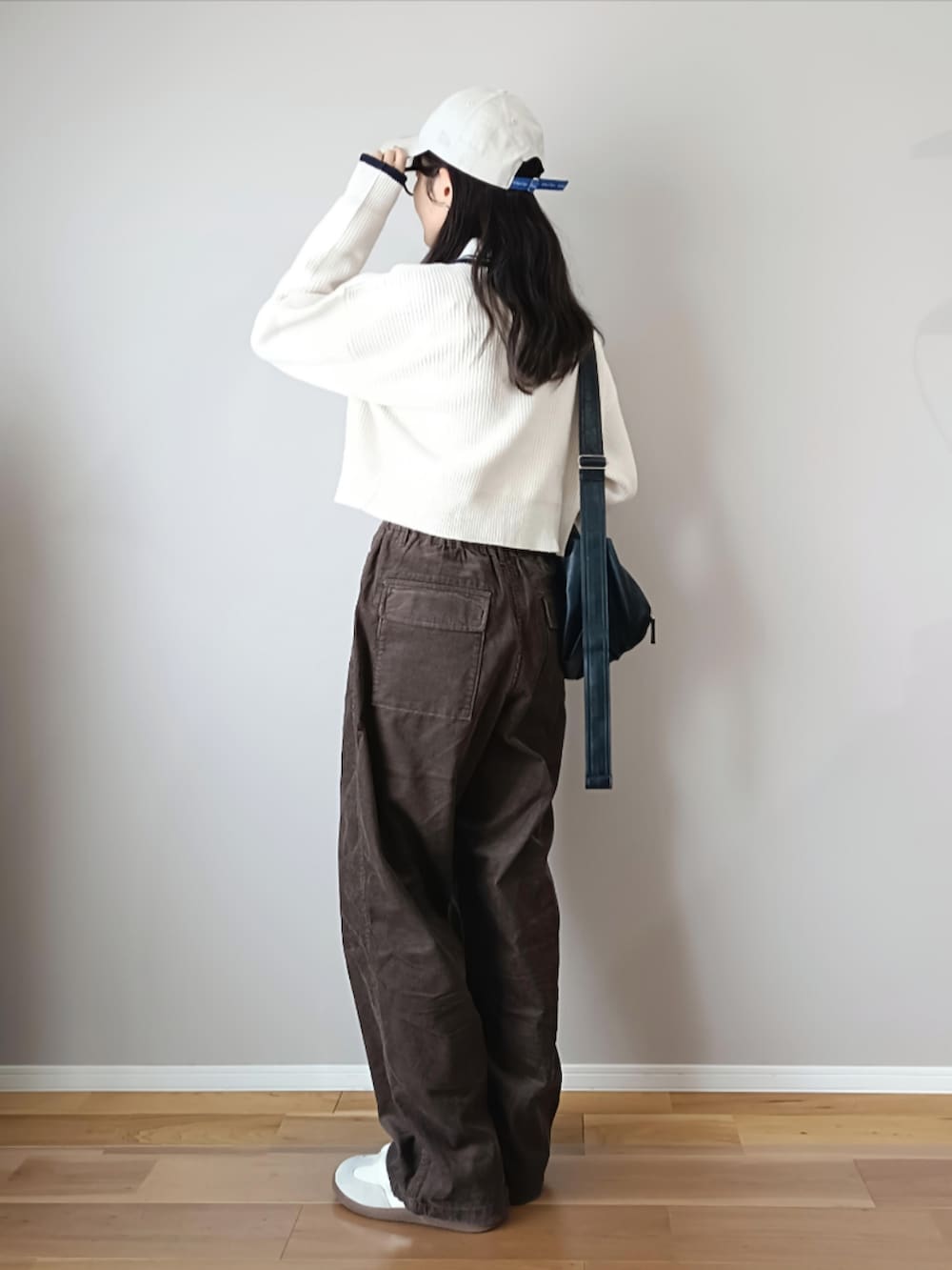 ホワイト系のニット/セーター、ブラウン系のパンツ、ブラック系のショルダーバッグを着用したレディースの秋コーディネートの3枚目の写真