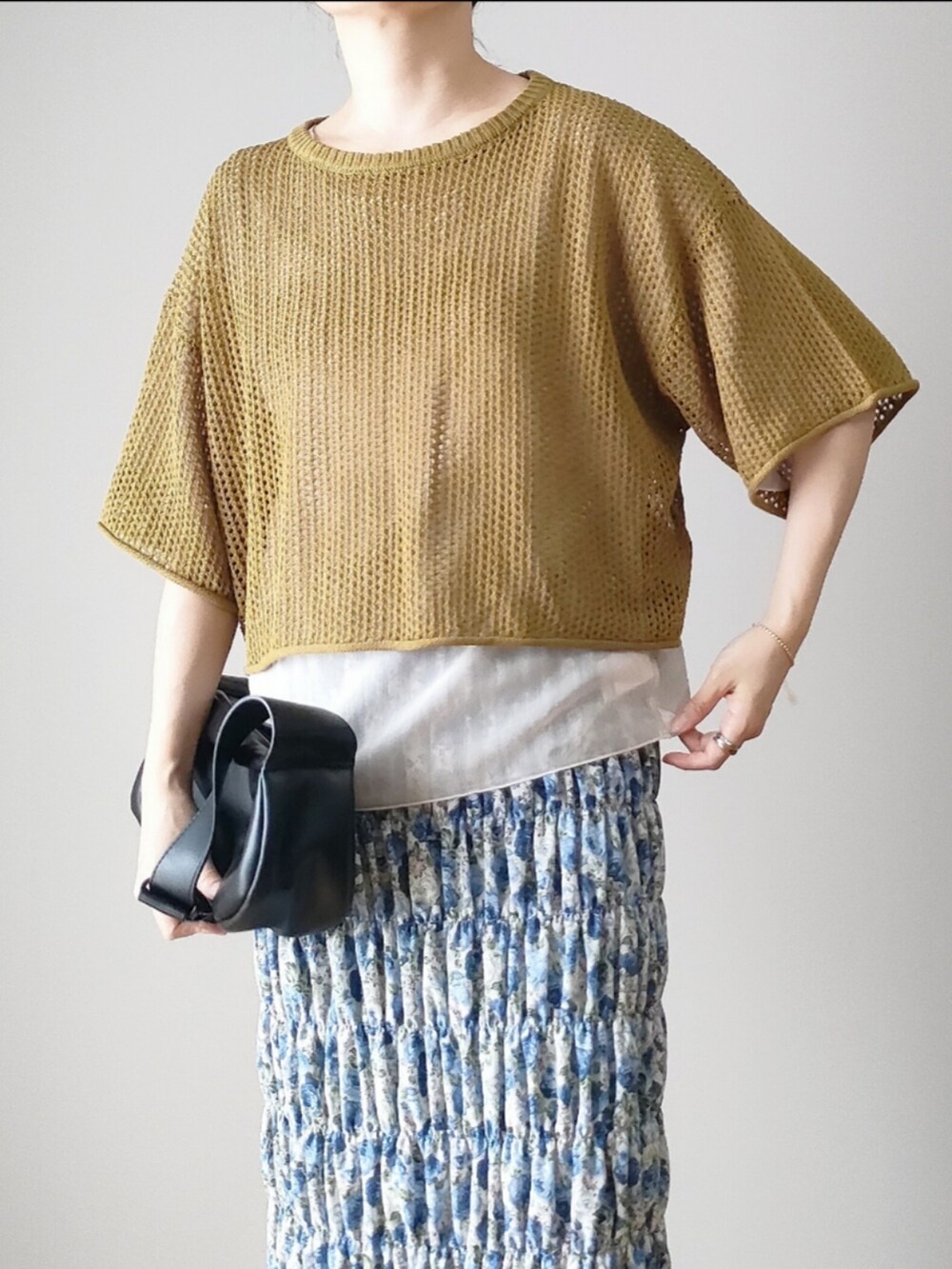 グリーン系のニット/セーター、ホワイト系のシャツ/ブラウス、ブルー系のスカートを着用したレディースの夏コーディネートの3枚目の写真