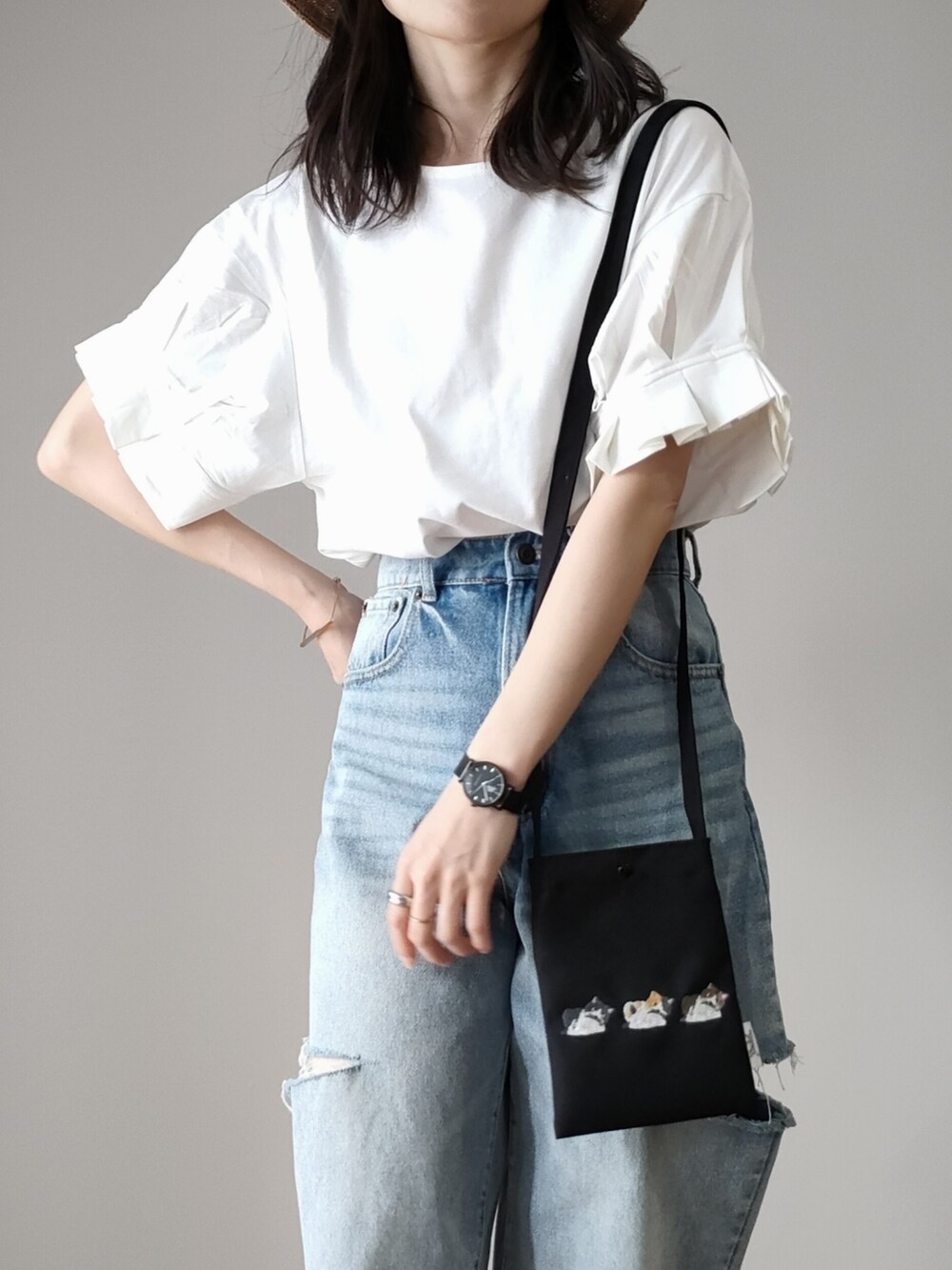 ホワイト系のTシャツ/カットソー、グレー系のサンダル、ブルー系のデニムパンツを着用したレディースの春コーディネートの2枚目の写真