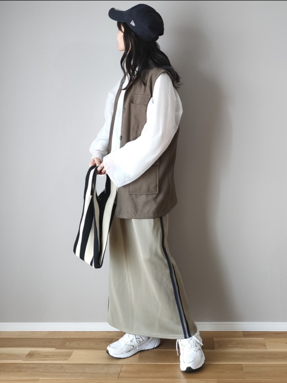 ホワイト系のシャツ/ブラウス、グリーン系のベスト、ブルー系のスカートを着用したレディースの秋コーディネートの4枚目の写真