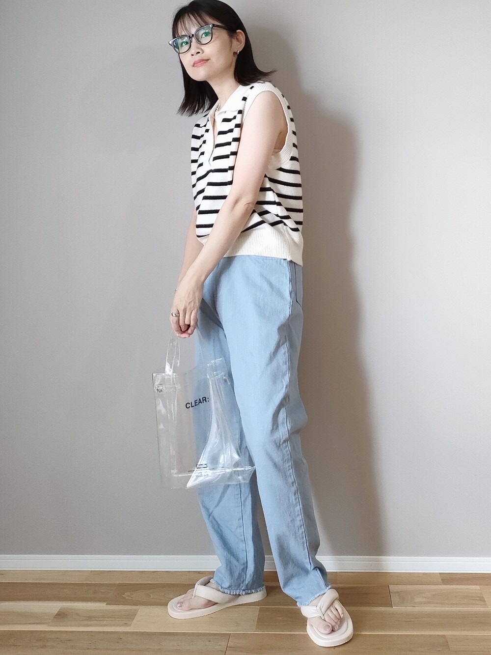 ホワイト系のベスト、ピンク系のデニムパンツ、ホワイト系のサンダルを着用したレディースの夏コーディネートの2枚目の写真